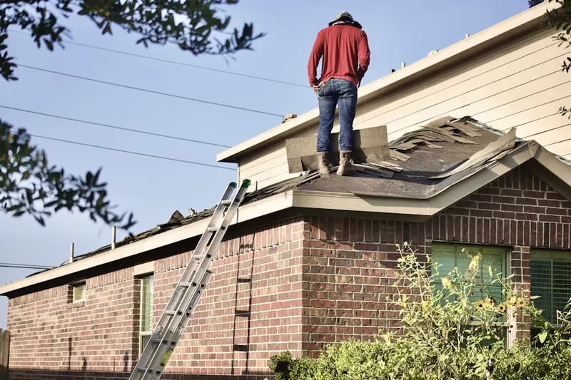 Professional roofer working on a residential roof in Cherbourg